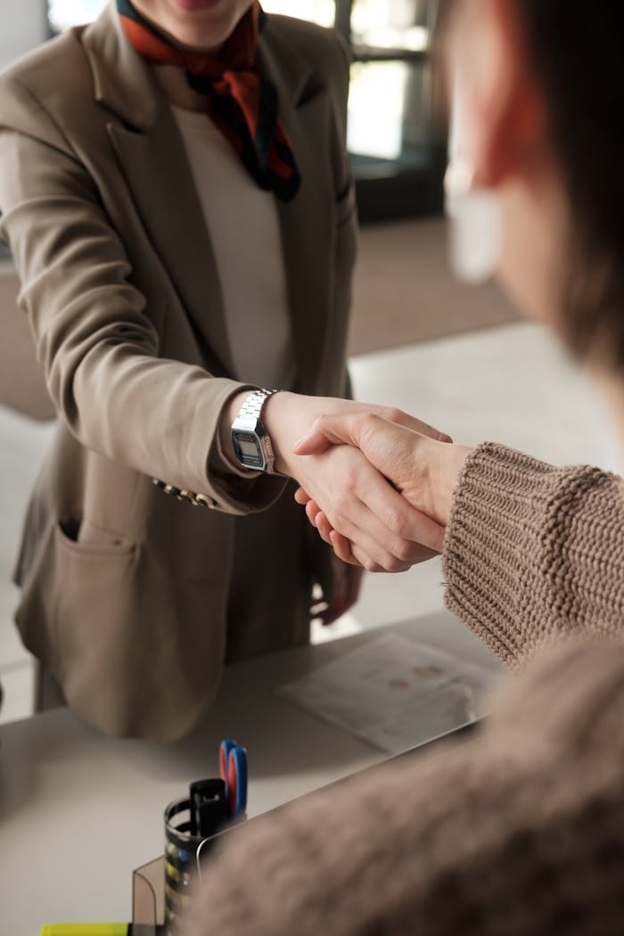Mastering the First Impression: Your intriguing post title goes here Two professionals shaking hands in an office, signifying a successful business agreement.